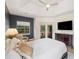 Relaxing bedroom with backyard pool view, tray ceiling, light wood floors, and a modern ceiling fan at 6212 Nimes Ct, Lutz, FL 33558