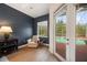 Cozy bedroom featuring an armchair, hardwood floors, neutral colors, and access to a pool at 6212 Nimes Ct, Lutz, FL 33558