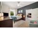 Comfortable bedroom with an accent wall, TV, and doorway to another room at 6212 Nimes Ct, Lutz, FL 33558