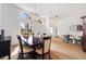 Open-concept dining area with wood floors, an elegant chandelier, and large windows at 6212 Nimes Ct, Lutz, FL 33558