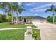 Charming single-story home with manicured lawn, mature trees, and a three-car garage at 6212 Nimes Ct, Lutz, FL 33558