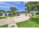 Beautifully landscaped home featuring a circular driveway and a three-car garage at 6212 Nimes Ct, Lutz, FL 33558