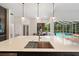 Quartz counter kitchen island with dark wood cabinets and a view to the backyard swimming pool at 6212 Nimes Ct, Lutz, FL 33558