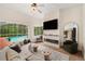 Stylish living room with view of the pool, modern fireplace, and comfortable seating area at 6212 Nimes Ct, Lutz, FL 33558