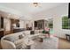 Open concept living room connected to a modern kitchen and a view to the backyard pool at 6212 Nimes Ct, Lutz, FL 33558