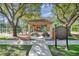 Community playground featuring a covered picnic area, various playground elements, and lush trees at 6212 Nimes Ct, Lutz, FL 33558