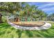 Community playground featuring modern equipment and a soft, safe play surface, surrounded by mature trees at 6212 Nimes Ct, Lutz, FL 33558