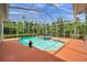 Screened-in pool featuring an in-ground spa and a spacious coral deck, perfect for outdoor entertaining at 6212 Nimes Ct, Lutz, FL 33558
