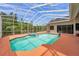 Screened-in pool featuring a spa, tile accents, and clear blue water perfect for relaxation at 6212 Nimes Ct, Lutz, FL 33558