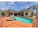 Screened-in pool featuring an in-ground spa and a spacious coral deck, perfect for outdoor entertaining at 6212 Nimes Ct, Lutz, FL 33558