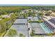 Aerial shot showcasing multiple tennis courts surrounded by lush greenery and with a view of a scenic lake at 6212 Nimes Ct, Lutz, FL 33558