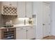 Elegant wet bar features a wine refrigerator, stylish cabinetry, and a backsplash for a sophisticated touch at 6811 Jared Oaks Dr, Wesley Chapel, FL 33545