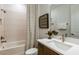 Well-lit bathroom with a shower-tub combo, modern vanity, and stylish mirror at 6811 Jared Oaks Dr, Wesley Chapel, FL 33545