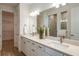 Modern bathroom featuring a double vanity with quartz countertop and a large mirror at 6811 Jared Oaks Dr, Wesley Chapel, FL 33545