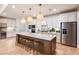 A gorgeous kitchen featuring a large center island with seating, stainless steel appliances, and modern pendant lights at 6811 Jared Oaks Dr, Wesley Chapel, FL 33545