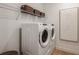 Functional laundry room with modern appliances, overhead shelving, and stylish decor at 6811 Jared Oaks Dr, Wesley Chapel, FL 33545