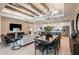 Open-concept living room features wood ceiling beams, modern chandeliers and flows into the kitchen at 6811 Jared Oaks Dr, Wesley Chapel, FL 33545