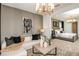 Cozy living room featuring a modern sofa, decorative art, and an open doorway to the main bedroom at 6811 Jared Oaks Dr, Wesley Chapel, FL 33545