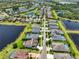 Scenic aerial view of homes with lakefront property, each with private pools and lush lawns at 6913 Park Strand Dr, Apollo Beach, FL 33572