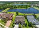 Aerial view of a home, showcasing a large backyard, nearby lake, and mature trees at 6913 Park Strand Dr, Apollo Beach, FL 33572