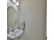 Powder room with a pedestal sink, oval mirror, and neutral-colored wall at 6913 Park Strand Dr, Apollo Beach, FL 33572