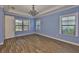 Bright bedroom with wood floors, neutral walls, and ample natural light from large windows at 6913 Park Strand Dr, Apollo Beach, FL 33572