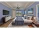 A beautifully furnished bedroom with hardwood floors, a tray ceiling, and stylish decor at 6913 Park Strand Dr, Apollo Beach, FL 33572