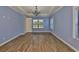 Bedroom with wood flooring, a large window, and neutral paint, illuminated by a chandelier at 6913 Park Strand Dr, Apollo Beach, FL 33572