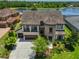 Beautiful home featuring an inviting front porch, lush landscaping, and a three-car garage at 6913 Park Strand Dr, Apollo Beach, FL 33572