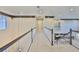 Upstairs hallway with trim, neutral carpet, white banister with dark handrail, and views of the stairwell and kitchen at 6913 Park Strand Dr, Apollo Beach, FL 33572