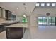 A modern kitchen with granite countertops opens to a living space with high ceilings and an outdoor patio at 6913 Park Strand Dr, Apollo Beach, FL 33572