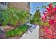 Close-up of a stone-clad home exterior, showcasing the walkway and vibrant landscaping at 6913 Park Strand Dr, Apollo Beach, FL 33572