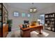Charming home office with custom shelving, rich wood desk, and a comfortable leather chair for a productive workspace at 6913 Park Strand Dr, Apollo Beach, FL 33572