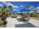 Outdoor picnic area with tables, blue umbrellas, and barbecue grills at 6913 Park Strand Dr, Apollo Beach, FL 33572