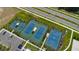 Aerial view of tennis and basketball courts surrounded by green landscaping and a parking lot at 6913 Park Strand Dr, Apollo Beach, FL 33572