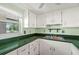 Classic kitchen with white cabinets, stainless steel sink, and a view of the outdoors at 7701 Starkey Rd # 504, Seminole, FL 33777