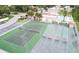 Aerial view of community tennis and shuffleboard courts surrounded by mature trees at 7701 Starkey Rd # 504, Seminole, FL 33777