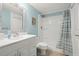 Clean bathroom featuring a shower with blue colored walls and updated vanity at 7701 Starkey Rd # 601, Seminole, FL 33777