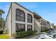 Exterior of a two-story apartment complex featuring a lush green lawn and mature trees at 7701 Starkey Rd # 601, Seminole, FL 33777