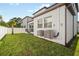 Lush green backyard features well-maintained lawn and the home's exterior, showcasing a clean and modern aesthetic at 7703 S Kissimmee St, Tampa, FL 33616