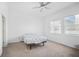 Bright bedroom featuring neutral carpet, two windows, and a ceiling fan at 7703 S Kissimmee St, Tampa, FL 33616
