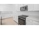 Well-equipped kitchen boasting stainless steel oven, microwave, and white cabinetry for a clean aesthetic at 7703 S Kissimmee St, Tampa, FL 33616