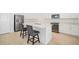 Modern kitchen with stainless steel appliances, quartz countertops, and an island with bar seating at 7703 S Kissimmee St, Tampa, FL 33616