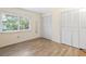 Bright bedroom featuring a window, wood floors, and a closet for ample storage space at 8350 40Th N Ave, St Petersburg, FL 33709