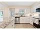 Bright kitchen featuring white cabinets, stainless steel appliances, granite counters, and natural light at 8350 40Th N Ave, St Petersburg, FL 33709