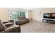 Cozy living room with a theater seating arrangement, wood-look tile floors, and a large window view at 8350 40Th N Ave, St Petersburg, FL 33709