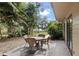 Outdoor patio with a wicker table and chairs surrounded by trees and lush greenery at 8350 40Th N Ave, St Petersburg, FL 33709