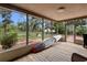 Screened in porch with wood floors, a paddle board, and view of the fenced in yard at 8350 40Th N Ave, St Petersburg, FL 33709
