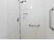 White tiled shower with a shower head, grab bars, and a recessed shelf at 8350 40Th N Ave, St Petersburg, FL 33709