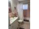 Charming bathroom with retro pink tile, a full tub, and a bright window at 8455 112Th St # 212, Seminole, FL 33772